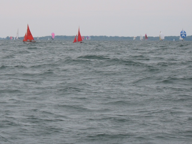 Photo: Les and Heather Reach for the Gybe Mark with a Keelboat Race in the Background